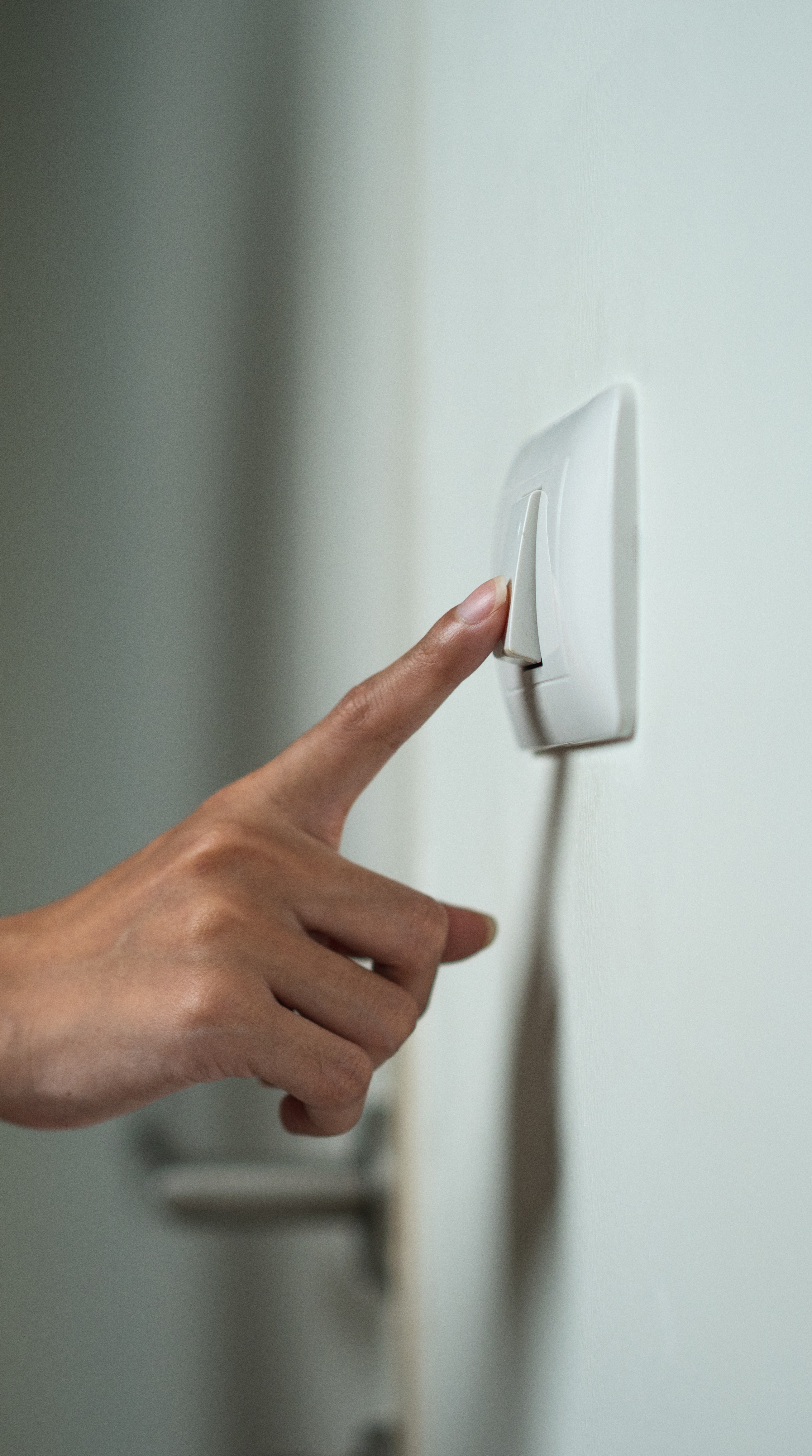 Mujer tocando el interruptor de la luz