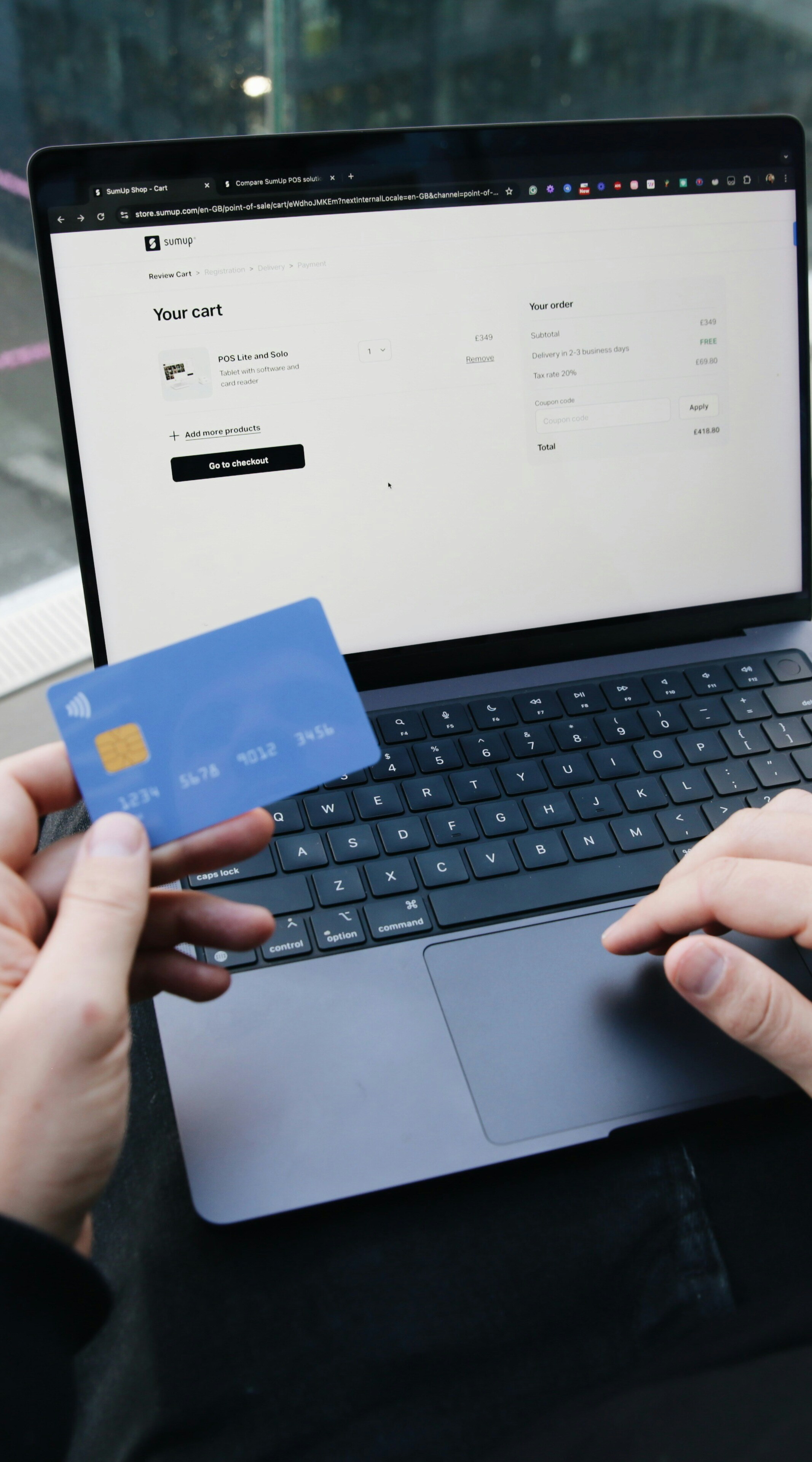 Persona comprando por Internet con una tarjeta y un portátil